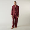 View 8 of product The Turnbull & Asser Burgundy Linen Modern Pyjama Set features a button-up, collared long-sleeve top with black piping and three pockets, plus matching pants with an elastic waistband.