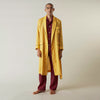 View 3 of product The Turnbull & Asser Ochre Linen Piped Gown features black piping on the collar, cuffs, and edges, a chest pocket, two front pockets, and a matching waist belt. Made with breathable linen for comfort, shown against a plain white background.