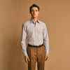 View 1 of product A man stands against a beige background, wearing a Turnbull & Asser Blue, Orange & Navy Multi Stripe Regular Fit Shirt with T&A collar and 3-button cuffs, tucked into tan dress pants with a black belt. He faces forward with a neutral expression.
