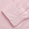 View 4 of product The Turnbull & Asser Pink Piped End-On-End Cotton Nightshirt features long sleeves, a pointed collar, button-down front, chest pocket, and a curved high-low hem for timeless, relaxed style.