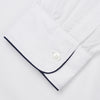 View 3 of product The Turnbull & Asser White Piped Cotton Nightshirt features black piping on the collar, chest pocket, and cuffs, plus a curved hem and loose-fitting sleeves gathered at the wrists for a classic look.