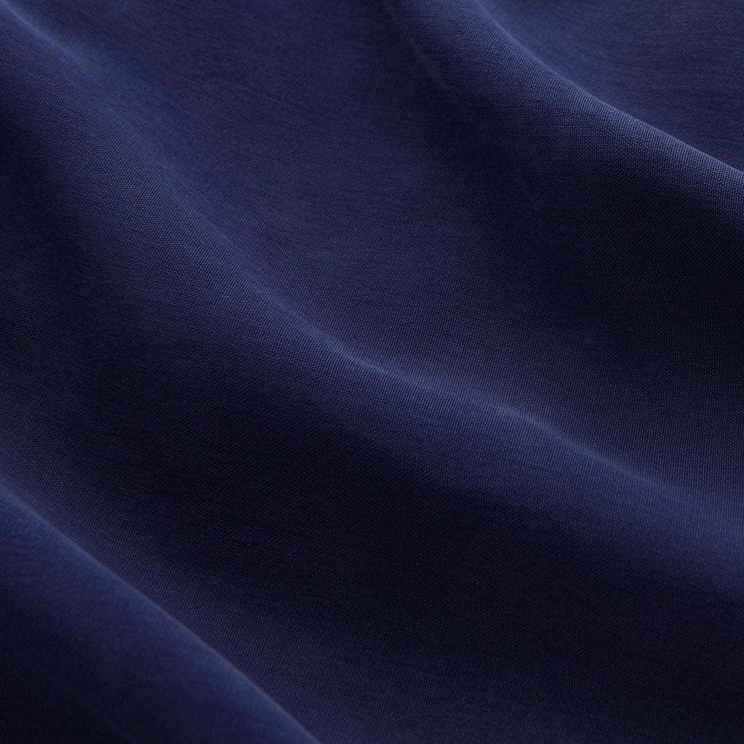 View 5 of product The Women's Harriet Navy Silk Pyjama Set by Turnbull & Asser features a long-sleeve, button-up top with white piping and chest pocket, plus matching drawstring pants—luxurious sleepwear displayed on a white background.