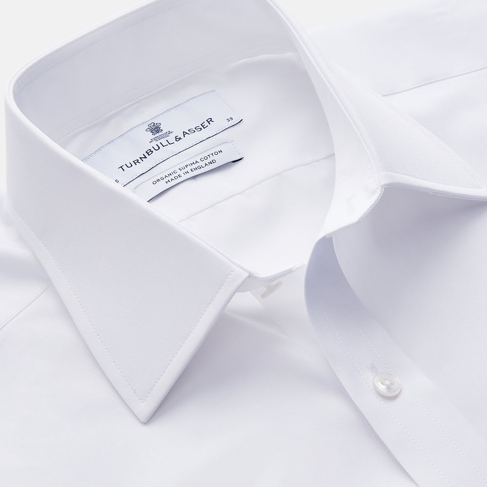 The Turnbull & Asser White Organic Cotton Regular Fit Mayfair Shirt features long sleeves, a classic collar, and button-down front, shown laid flat against a white background.