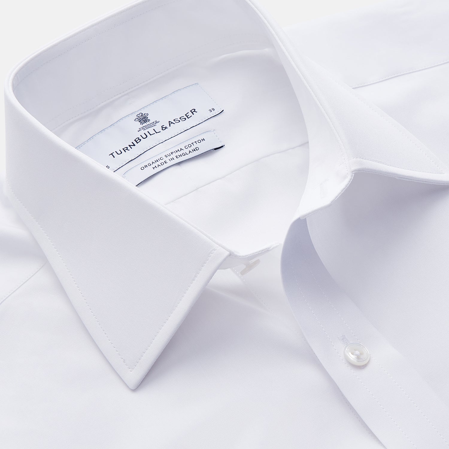 View 2 of product The Turnbull & Asser White Organic Cotton Regular Fit Mayfair Shirt features long sleeves, a classic collar, and button-down front, shown laid flat against a white background.