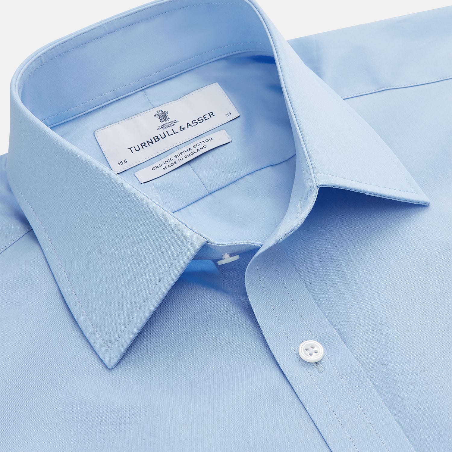 View 2 of product The Turnbull & Asser Pale Blue Organic Cotton Regular Fit Mayfair Shirt features long sleeves, a pointed collar, white buttons, and buttoned cuffs, shown laid flat on a white background.
