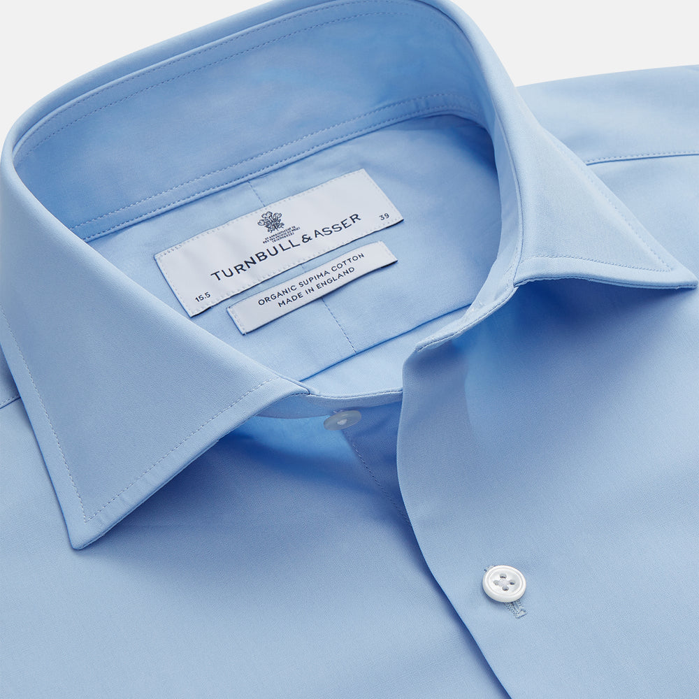The Turnbull & Asser Pale Blue Organic Cotton Tailored Fit Hove Shirt is a formal long-sleeve button-up with a classic collar and white buttons, crafted from premium organic cotton and shown on a plain white background.