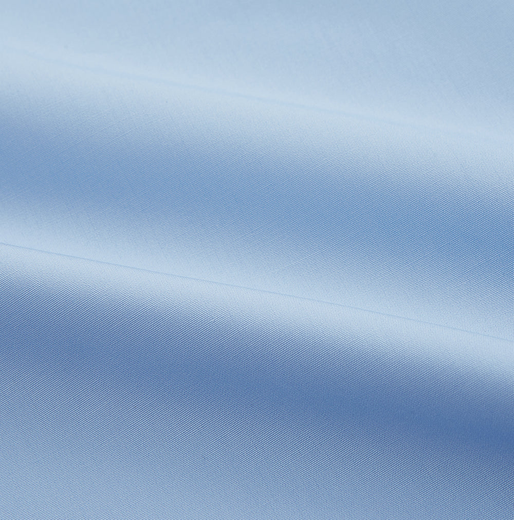The Turnbull & Asser Pale Blue Organic Cotton Tailored Fit Hove Shirt is a formal long-sleeve button-up with a classic collar and white buttons, crafted from premium organic cotton and shown on a plain white background.
