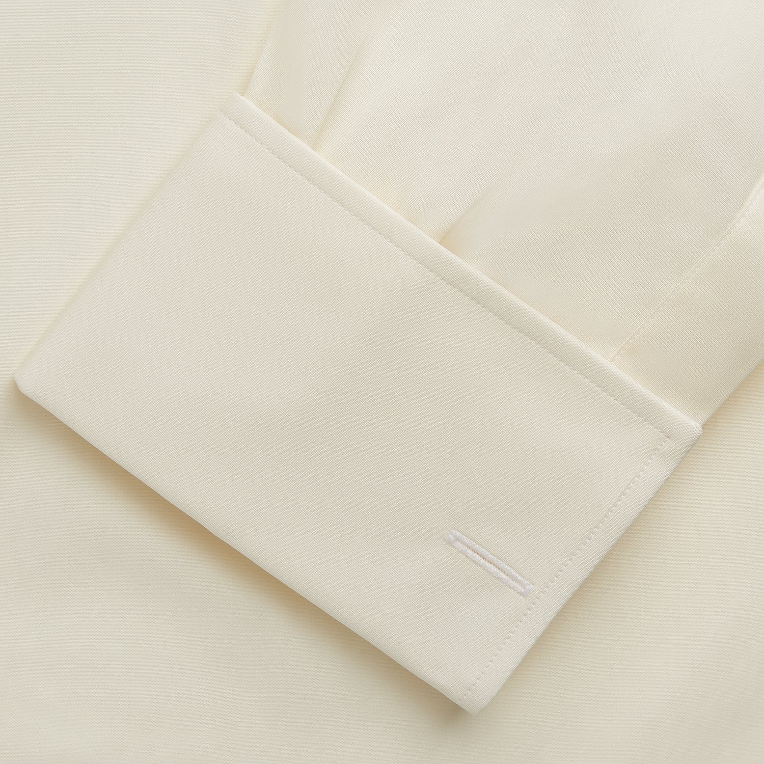 View 3 of product The Turnbull & Asser Tailored Fit Cream Cotton Shirt features a Kent collar and double cuffs, shown laid flat against a white background—ideal for pairing with statement ties.
