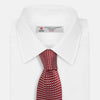 View 2 of product The Turnbull & Asser Burgundy and White Diamond Silk Tie features a rolled-up design with a repeating white diamond pattern on burgundy, shown on a plain white background—a timeless accent for any office shirt.
