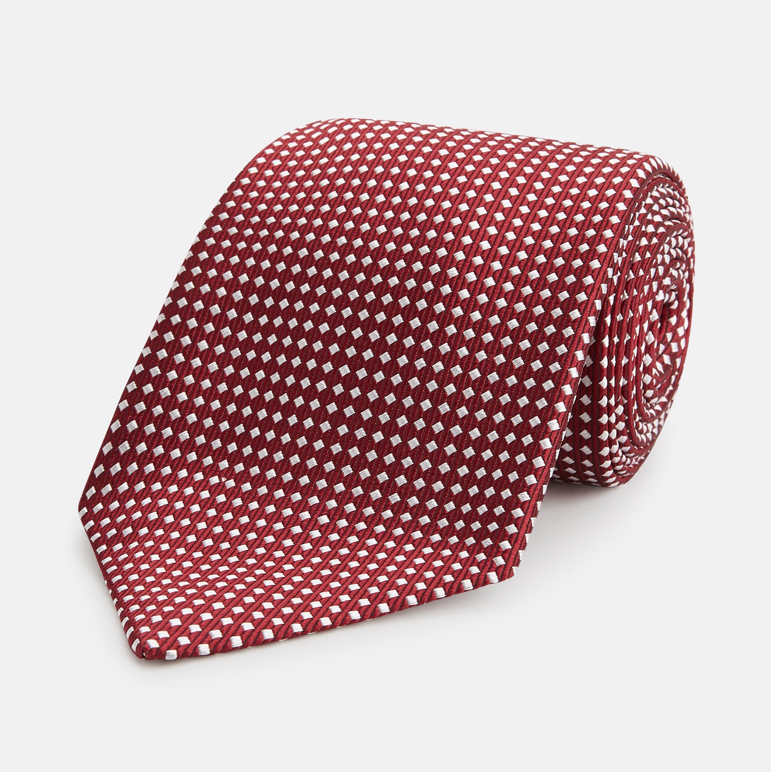 View 1 of product The Turnbull & Asser Burgundy and White Diamond Silk Tie features a rolled-up design with a repeating white diamond pattern on burgundy, shown on a plain white background—a timeless accent for any office shirt.