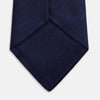 View 4 of product The Long Navy Herringbone Silk Tie by Turnbull & Asser is shown rolled up on a plain white background, highlighting its subtle herringbone weave and luxurious silk fabric.