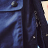 View 5 of product The Turnbull & Asser Navy Dry-Waxed Cotton Field Jacket features a collar, front zipper with snap buttons, two chest pockets, and large hip flap pockets, shown laid flat on a plain white background.