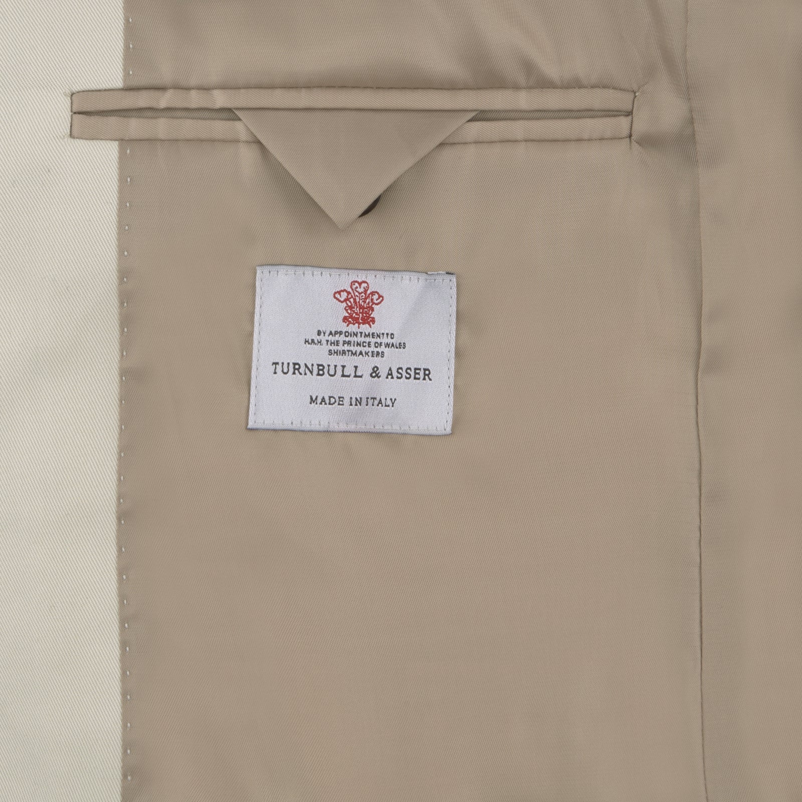 View 2 of product The Turnbull & Asser Stone Cotton Twill Jacket features a notch lapel, chest pocket, two front flap pockets, and brown buttons. Italian-tailored for smart-casual style, it is shown here against a white background.