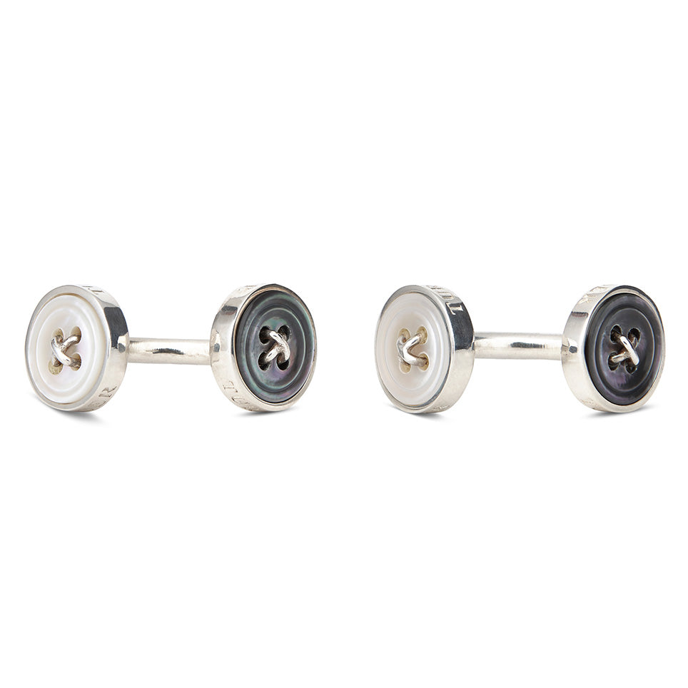 View 4 of product Turnbull & Asser’s Reversible Sterling Silver Mother-of-Pearl Button Cufflinks feature a round button design with four central holes, showcasing a dark iridescent face on one side and a light mother-of-pearl face on the other.