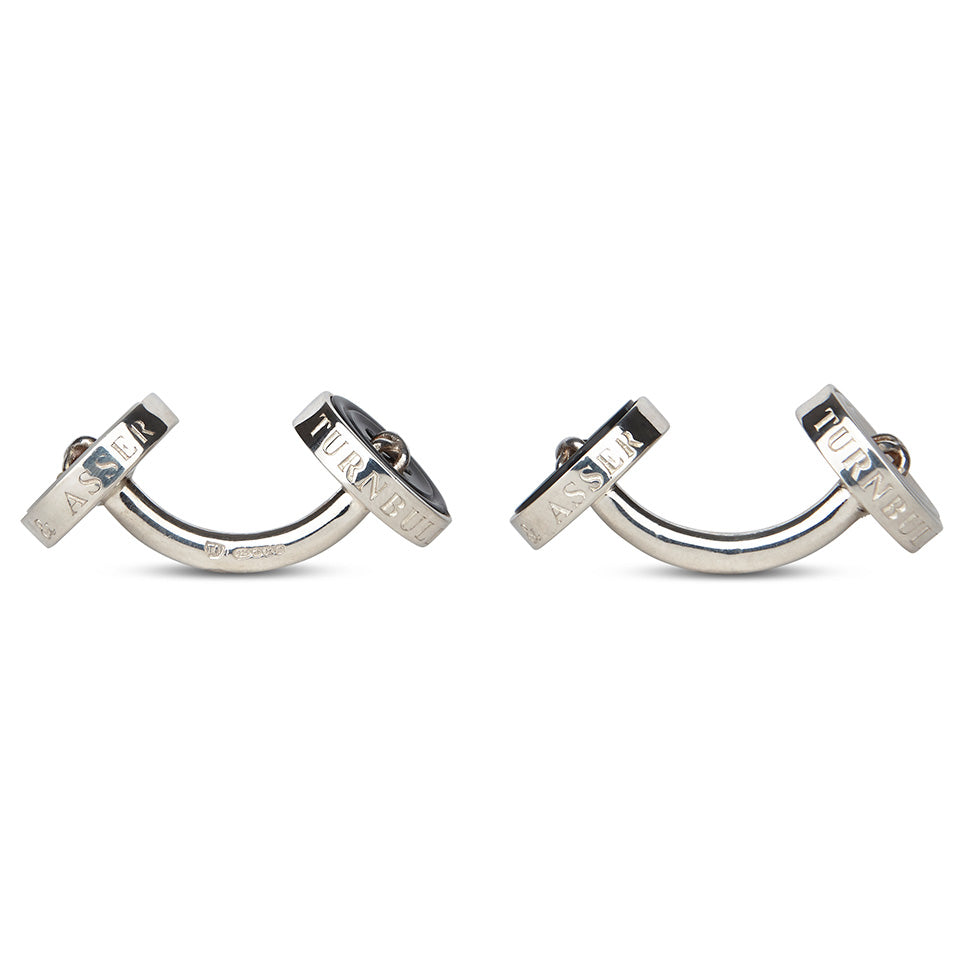 Turnbull & Asser’s Reversible Sterling Silver Mother-of-Pearl Button Cufflinks feature a round button design with four central holes, showcasing a dark iridescent face on one side and a light mother-of-pearl face on the other.