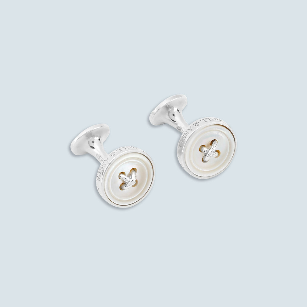 Turnbull & Asser's White Sterling Silver Mother-of-Pearl Button Cufflinks, designed with a four-hole button motif and mother-of-pearl center, are displayed on a light gray background.