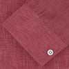 View 2 of product The Turnbull & Asser Weekend Fit Red Linen Shirt features a Dorset collar, 1-button cuff, white buttons, and patch pocket. The long-sleeve shirt is neatly folded and displayed on a plain white background.