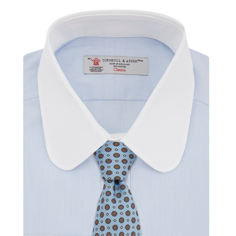 A neatly folded The Great Gatsby Cotton Shirt by Turnbull & Asser, featuring a light blue body, white rounded collar, and double cuffs inspired by 1920s style, displayed on a plain light background.