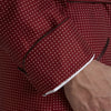 View 4 of product The Turnbull & Asser Burgundy Piped Silk Spot Gown features small white polka dots, a shawl collar, fabric belt, and chest pocket—luxurious nightwear and a stylish men’s statement piece—shown on a white background.