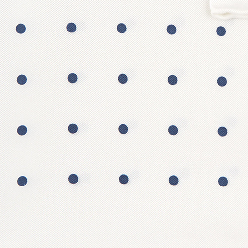 The White and Navy Spot Silk Pocket Square by Turnbull & Asser features evenly spaced blue dots and the brand's logo in blue on the bottom right, with a folded corner highlighting this classic men's accessory.