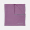 View 1 of product The Lilac and White Piped Silk Pocket Square by Turnbull & Asser features a smooth lilac silk fabric with a refined white piped edge and the brand's signature printed in white on the lower right corner.