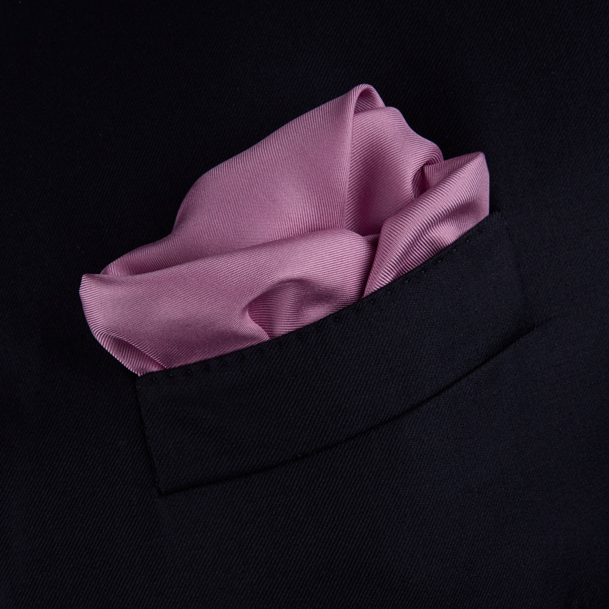 View 4 of product The Lilac and White Piped Silk Pocket Square by Turnbull & Asser features a smooth lilac silk fabric with a refined white piped edge and the brand's signature printed in white on the lower right corner.