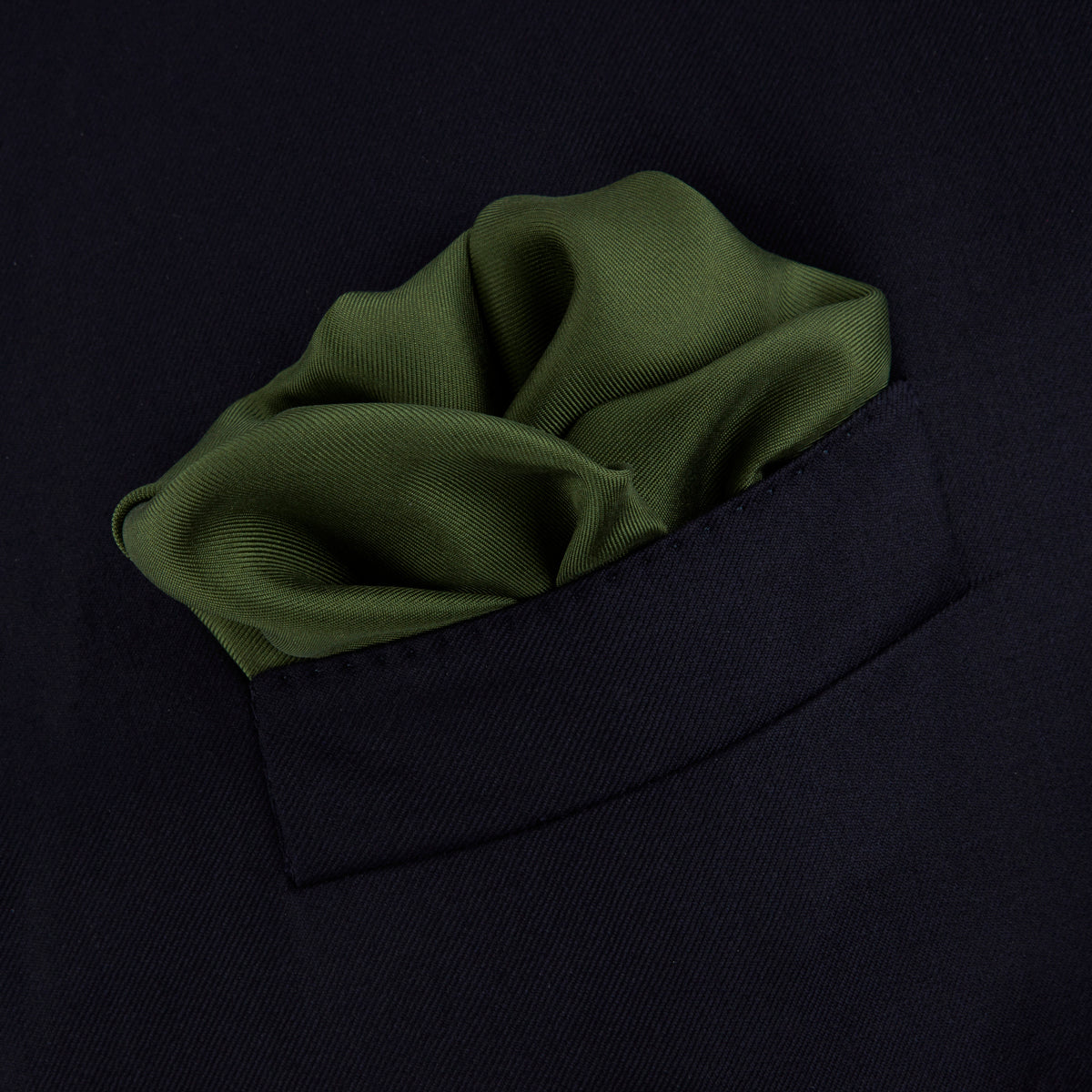 View 4 of product The Olive and White Piped Silk Pocket Square by Turnbull & Asser features a subtle white border and the brand’s embroidered logo—a timeless accessory for any occasion.
