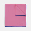 View 1 of product The Rose and Navy Piped Silk Pocket Square by Turnbull & Asser features classic pink silk with navy edging, neatly folded to display both sides. Turnbull & Asser’s logo appears in white on the lower right corner for a refined finish.