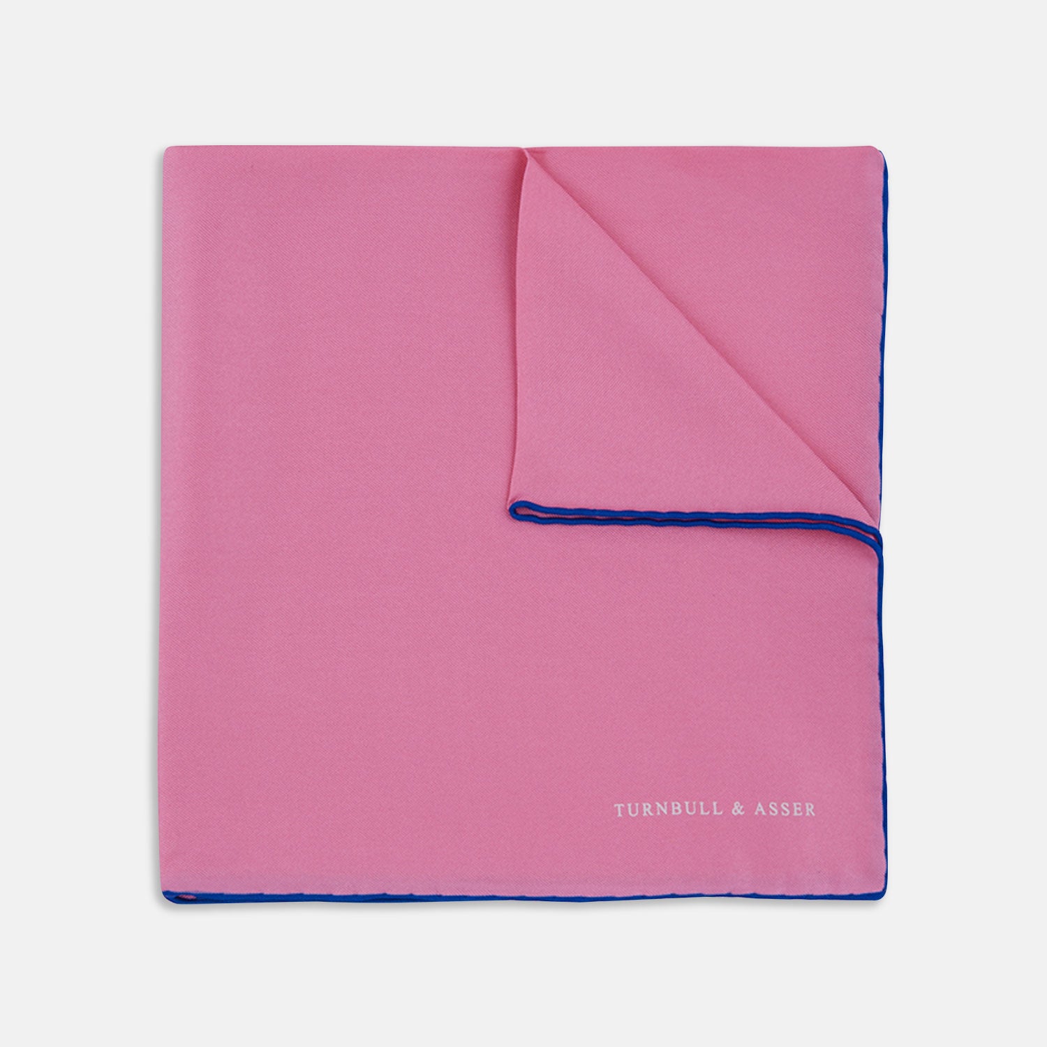 View 1 of product The Rose and Navy Piped Silk Pocket Square by Turnbull & Asser features classic pink silk with navy edging, neatly folded to display both sides. Turnbull & Asser’s logo appears in white on the lower right corner for a refined finish.