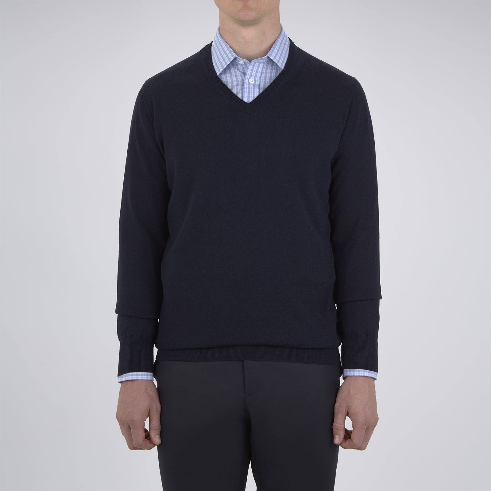 View 2 of product The Turnbull & Asser Indigo V-Neck Merino Wool Jumper, shown neatly folded with ribbed cuffs and a visible inner label, is a timeless essential in versatile navy, perfect for any gentleman’s wardrobe.