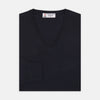 View 1 of product The Turnbull & Asser Indigo V-Neck Merino Wool Jumper, shown neatly folded with ribbed cuffs and a visible inner label, is a timeless essential in versatile navy, perfect for any gentleman’s wardrobe.