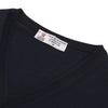 View 4 of product The Turnbull & Asser Indigo V-Neck Merino Wool Jumper, shown neatly folded with ribbed cuffs and a visible inner label, is a timeless essential in versatile navy, perfect for any gentleman’s wardrobe.