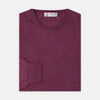 View 1 of product The Plum Fine Merino Crew Neck Jumper by Turnbull & Asser features classic Scottish knitwear craftsmanship in a rich maroon shade, shown neatly folded with long sleeves against a plain white background.