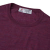 View 2 of product The Plum Fine Merino Crew Neck Jumper by Turnbull & Asser features classic Scottish knitwear craftsmanship in a rich maroon shade, shown neatly folded with long sleeves against a plain white background.