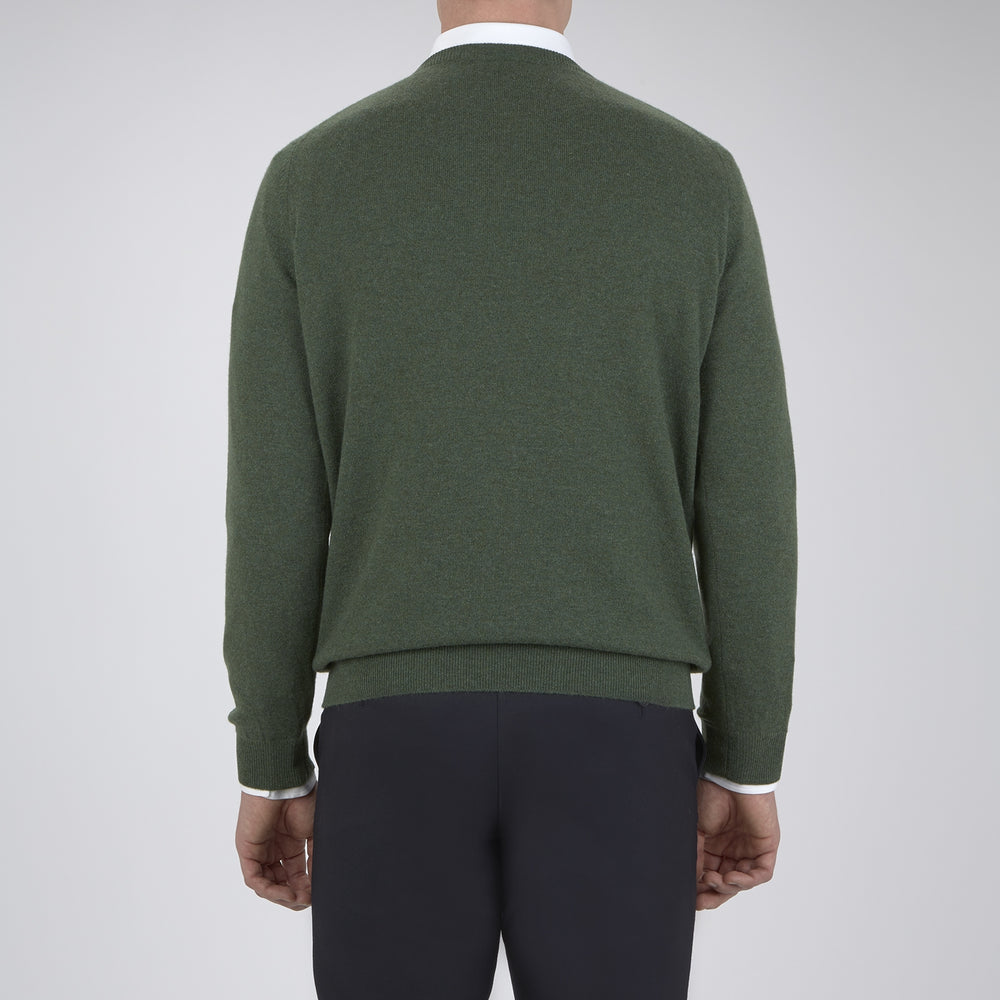 The Turnbull & Asser Green Crew Neck Cashmere Jumper, crafted from luxurious Scottish cashmere with ribbed cuffs, is neatly folded and displayed on a plain white background with the brand label visible inside the neckline.
