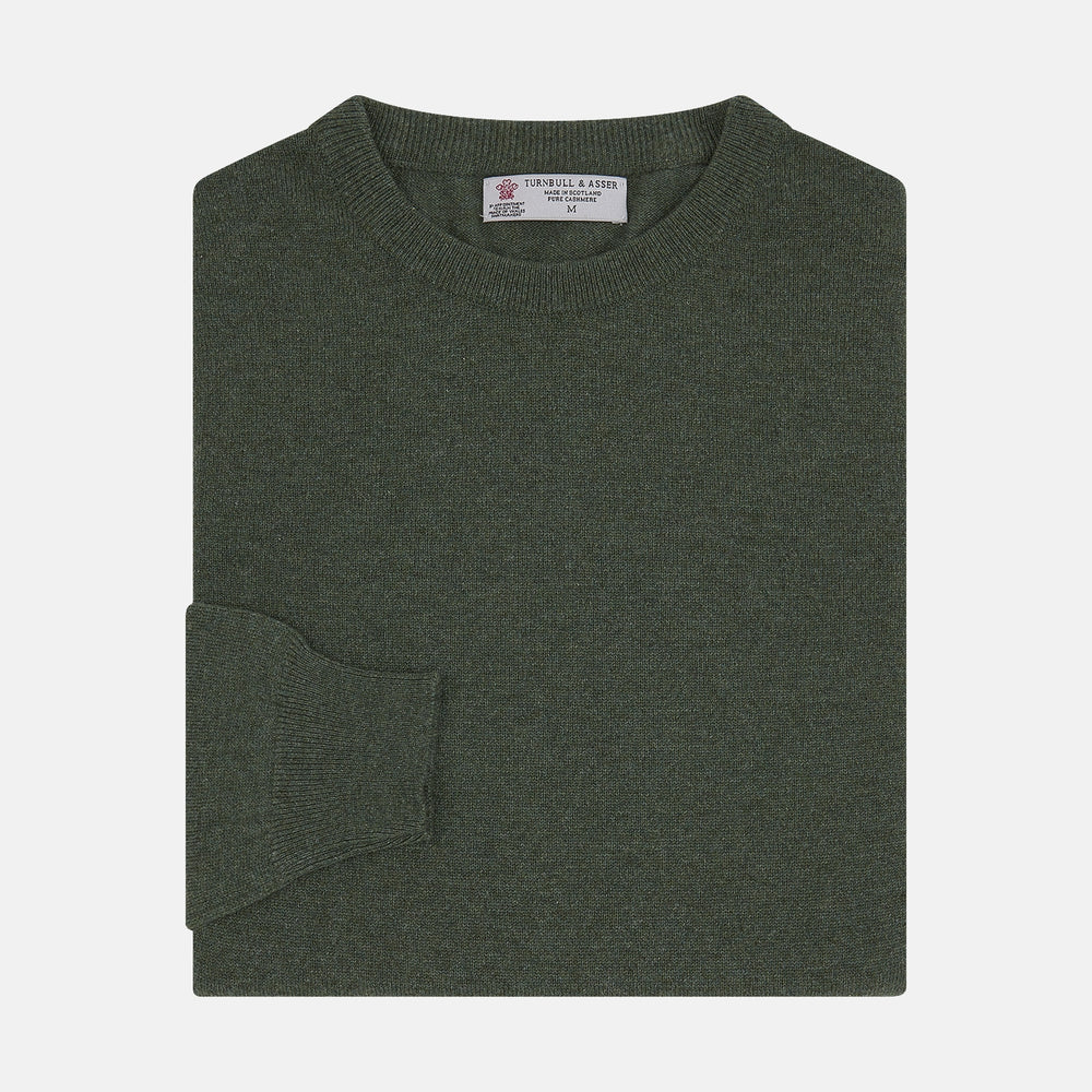 The Turnbull & Asser Green Crew Neck Cashmere Jumper, crafted from luxurious Scottish cashmere with ribbed cuffs, is neatly folded and displayed on a plain white background with the brand label visible inside the neckline.