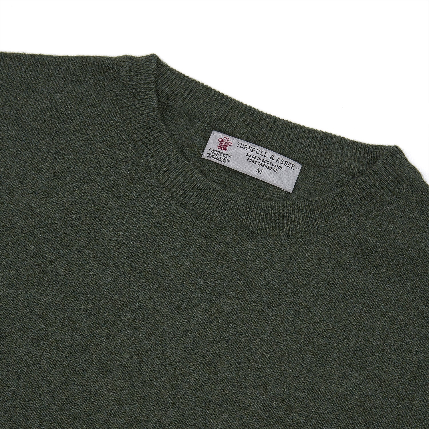View 4 of product The Turnbull & Asser Green Crew Neck Cashmere Jumper, crafted from luxurious Scottish cashmere with ribbed cuffs, is neatly folded and displayed on a plain white background with the brand label visible inside the neckline.