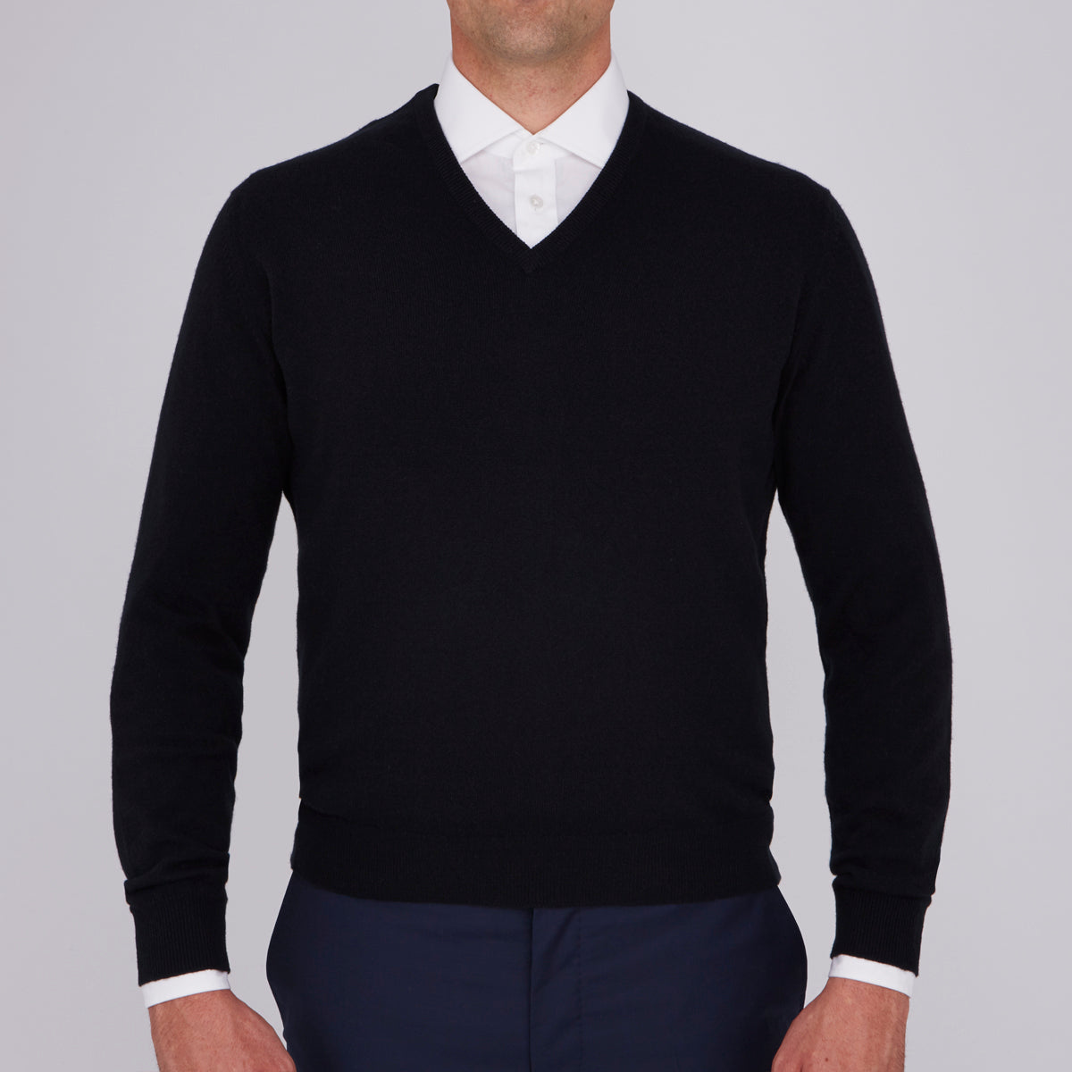 View 2 of product The Turnbull & Asser Black V-Neck Cashmere Jumper is neatly folded, crafted from luxury Scottish cashmere, and features a visible brand label inside the collar, displayed on a plain white background.