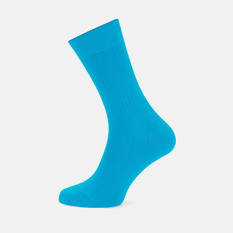 A single Turnbull & Asser Turquoise Short Cotton Sock stands upright against a plain light gray background, showcasing its ribbed texture and premium Fil d’Ecosse cotton.