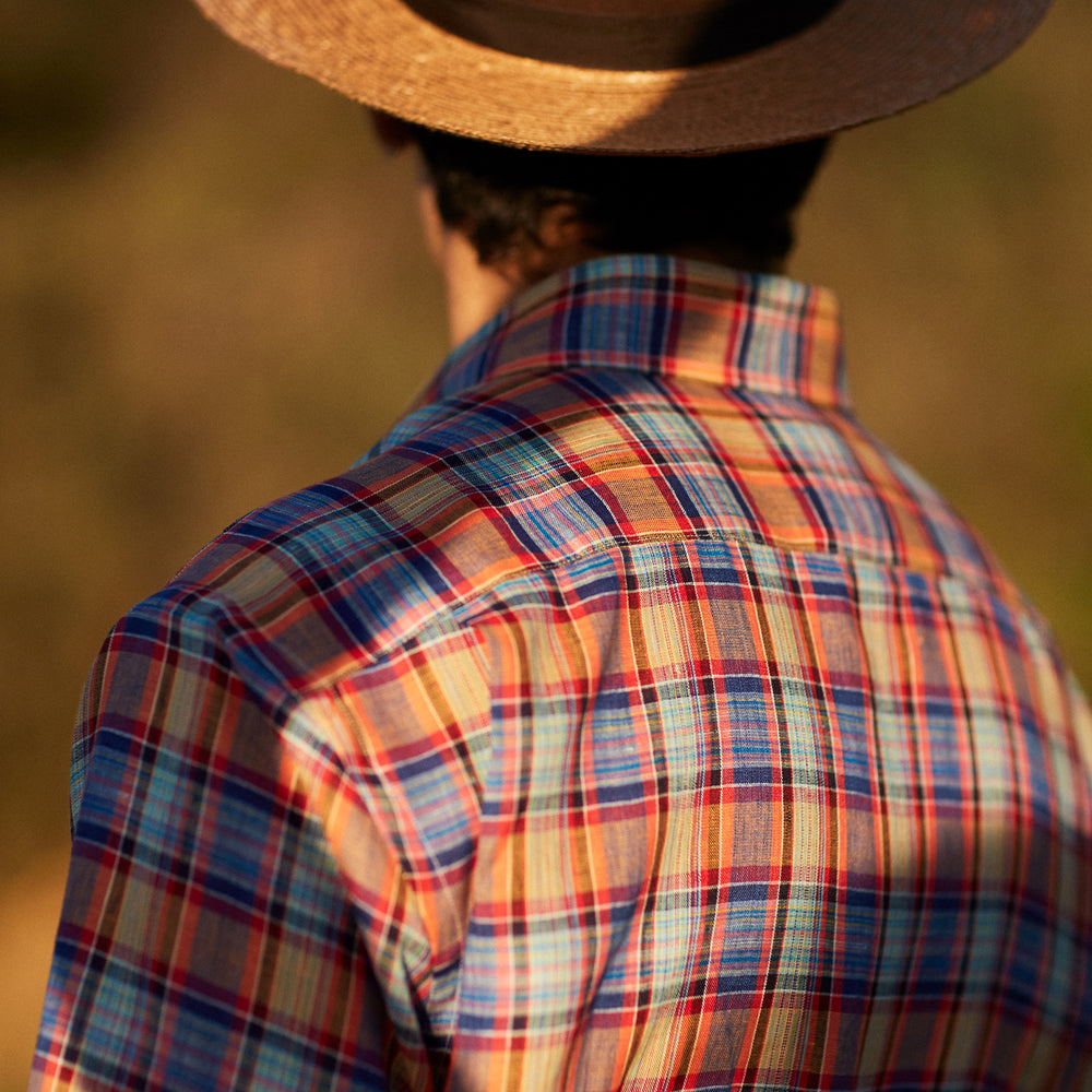 The Turnbull & Asser Blue and Orange Madras Check Weekend Fit Short Sleeve Linen Shirt features a colorful plaid pattern and a Dorset collar, shown against a plain white background.