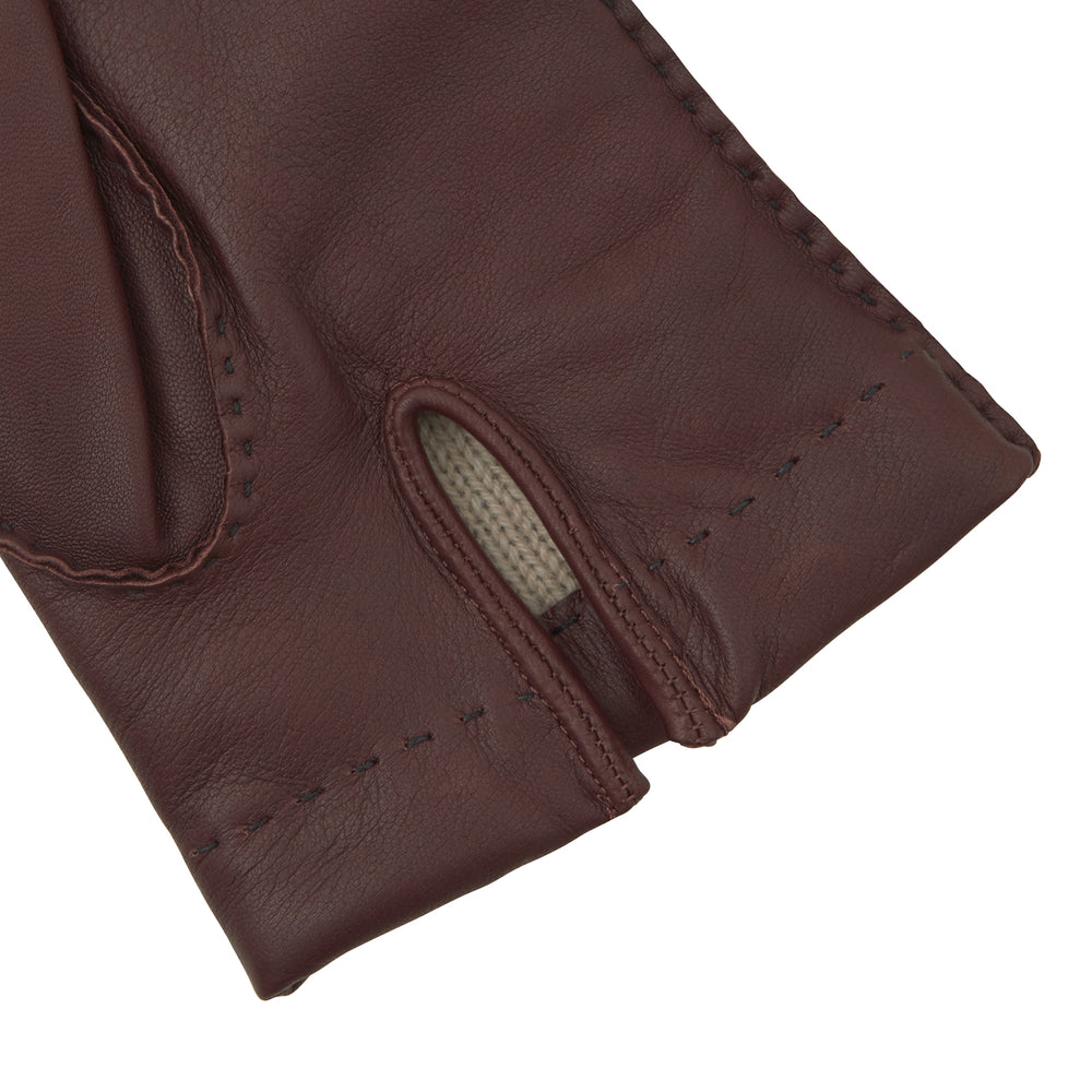 Turnbull & Asser’s Brown Hairsheep Leather Gloves, featuring visible stitching and decorative raised seams on the back, are displayed overlapping each other against a white background.