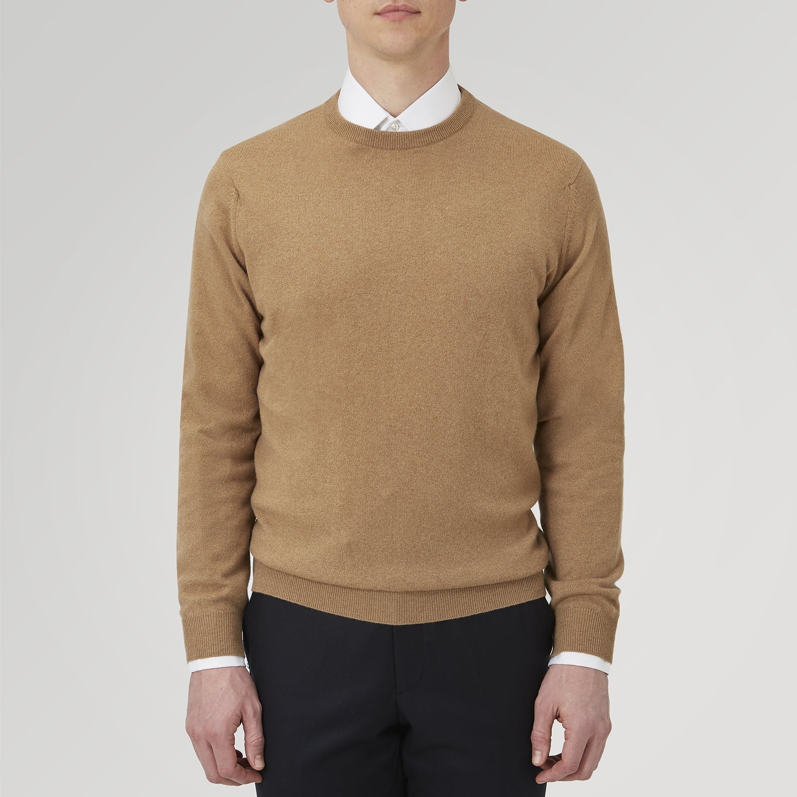 View 2 of product A folded Natural Crew Neck Cashmere Jumper by Turnbull & Asser, in light brown, features a visible brand label and one sleeve neatly laid across the front of this smart casual luxury Scottish sweater.