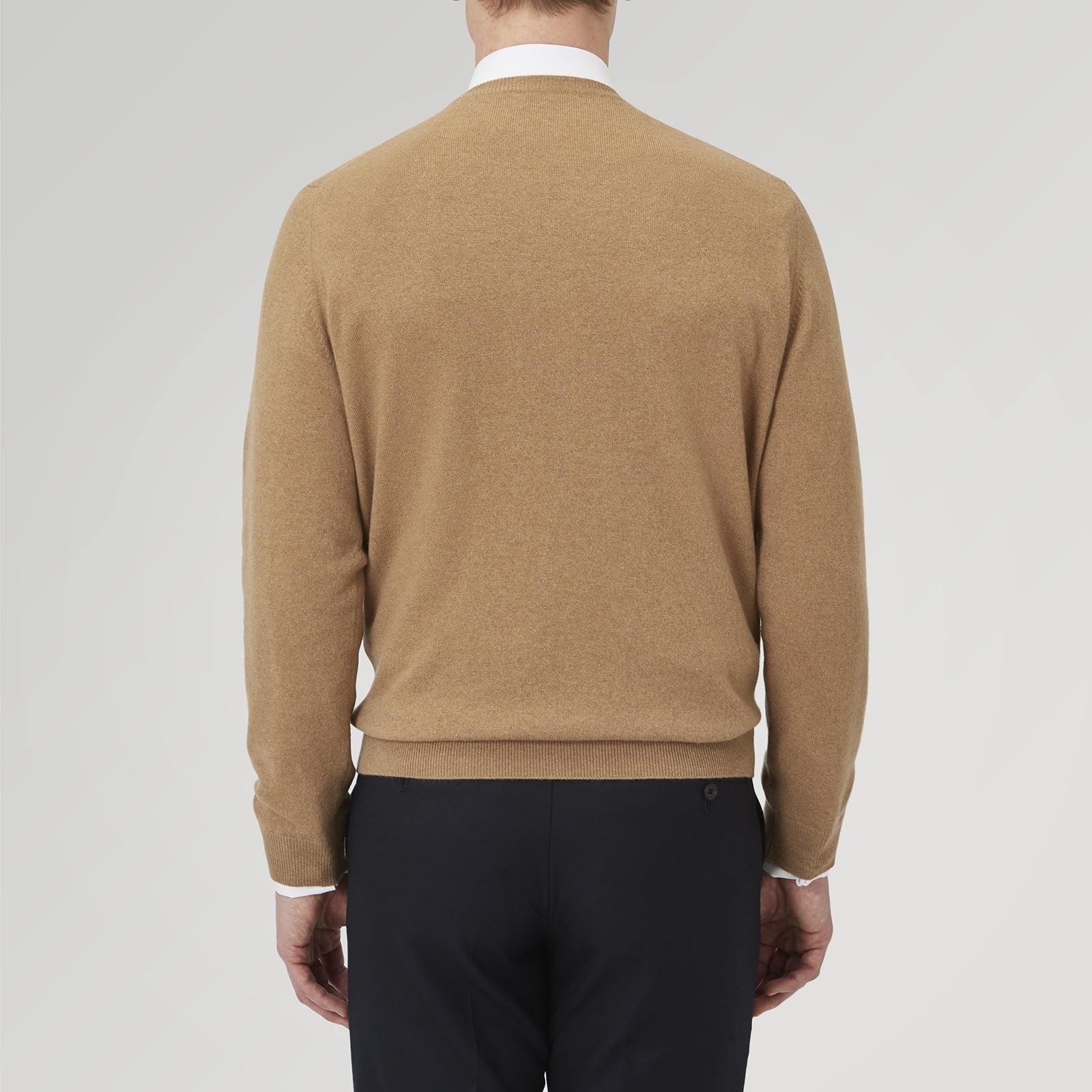 View 3 of product A folded Natural Crew Neck Cashmere Jumper by Turnbull & Asser, in light brown, features a visible brand label and one sleeve neatly laid across the front of this smart casual luxury Scottish sweater.