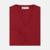 View 1 of product The Deep Red V-Neck Cashmere Jumper by Turnbull & Asser features long sleeves, ribbed cuffs and collar, and an inner collar label. Displayed on a white background, it's ideal for smart casual looks.