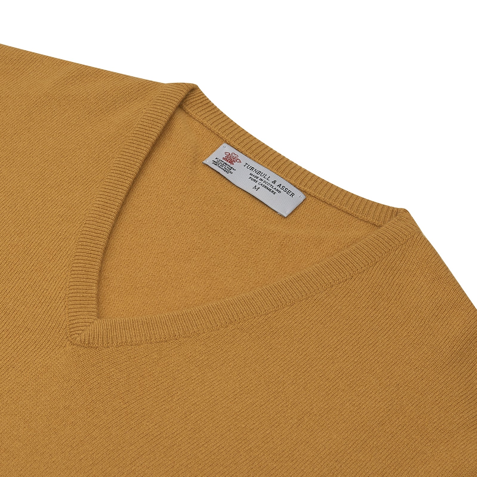 View 3 of product A Sunflower Yellow V-Neck Cashmere Jumper by Turnbull & Asser is neatly folded on a white background, with ribbed cuffs and a visible branded collar label, showcasing this luxurious knitwear piece.