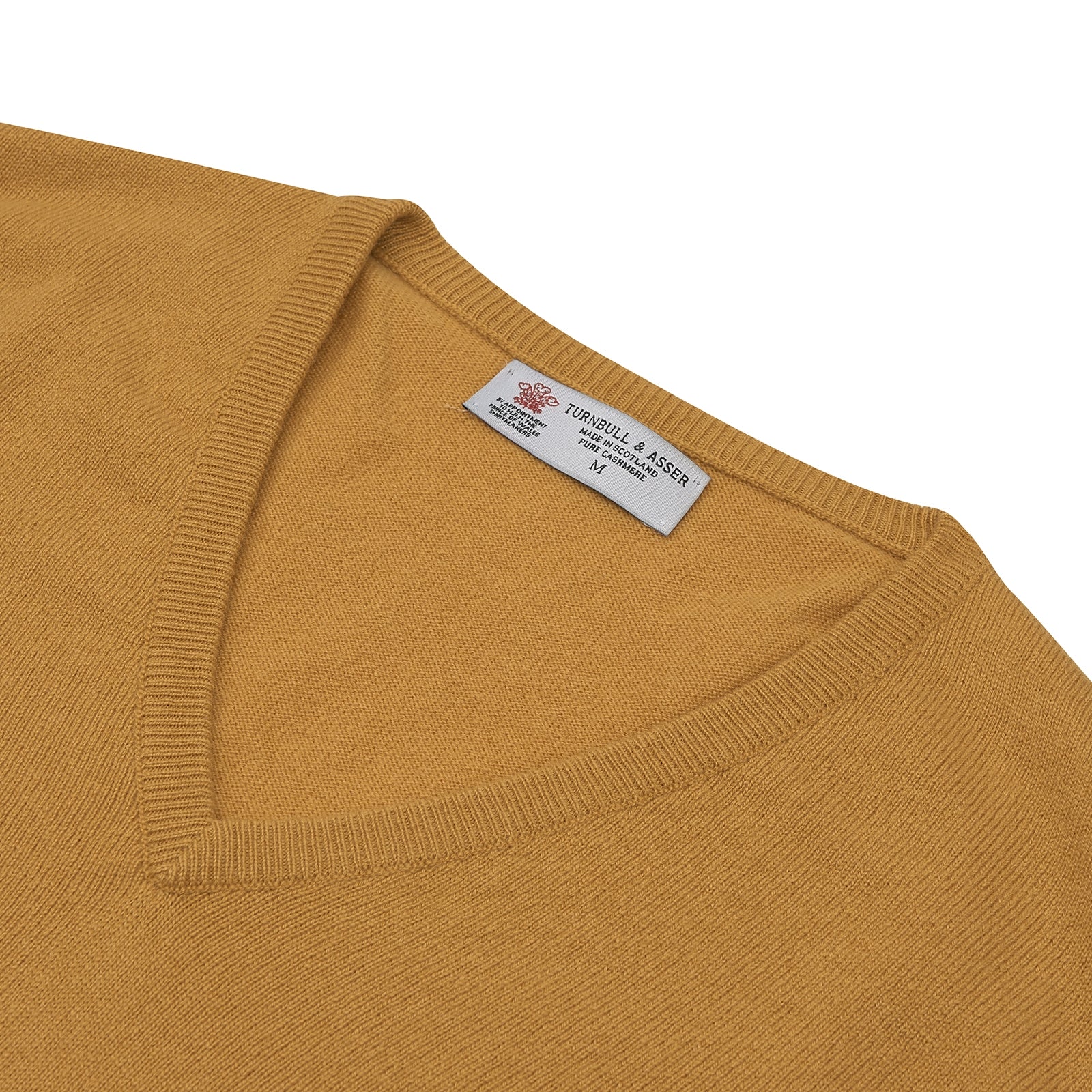 View 3 of product The Sunflower Yellow V-Neck Cashmere Slipover by Turnbull & Asser is neatly folded on a white background, showing the front and label—ideal for formal layering or as a versatile cashmere addition to your wardrobe.