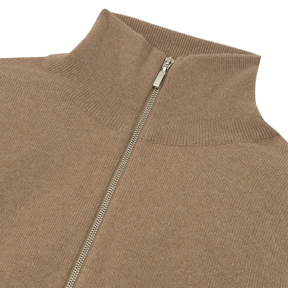 The Turnbull & Asser Natural Half-Zip Cashmere Jumper, light brown with a high collar and silver zip, is folded neatly against a white background. One sleeve shows its ribbed cuff—ideal for stylish layering.