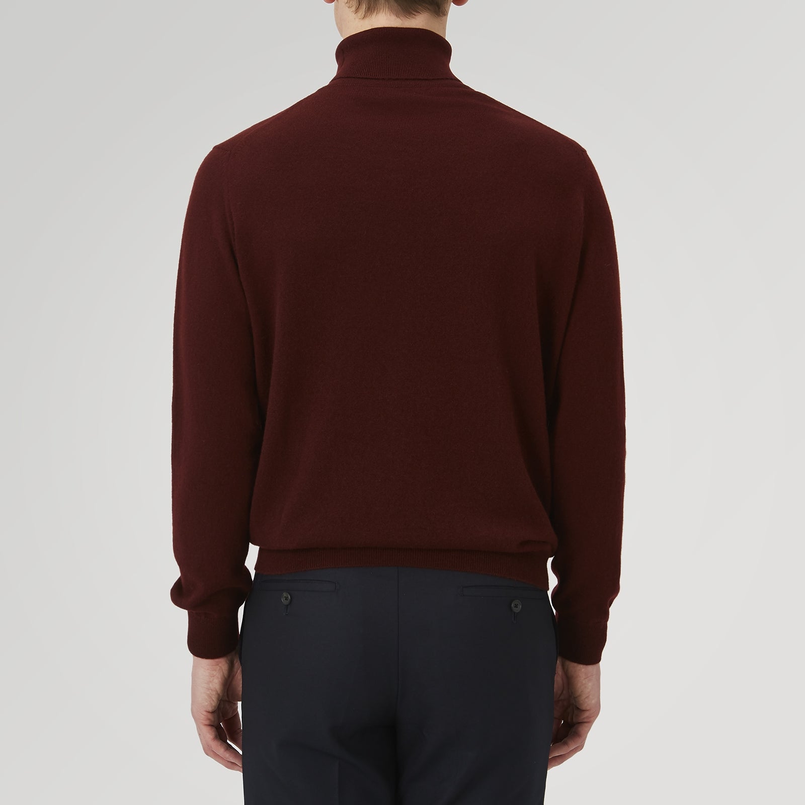 View 3 of product A folded, long-sleeve Port Cashmere Roll Neck Jumper by Turnbull & Asser in burgundy is displayed on a white background, highlighting this stylish men's autumn piece.