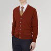 View 2 of product The Harissa Cashmere Cardigan by Turnbull & Asser, in deep red-brown 21GG knit, is folded to display its V-neck, ribbed cuffs, and two buttons against a white background.