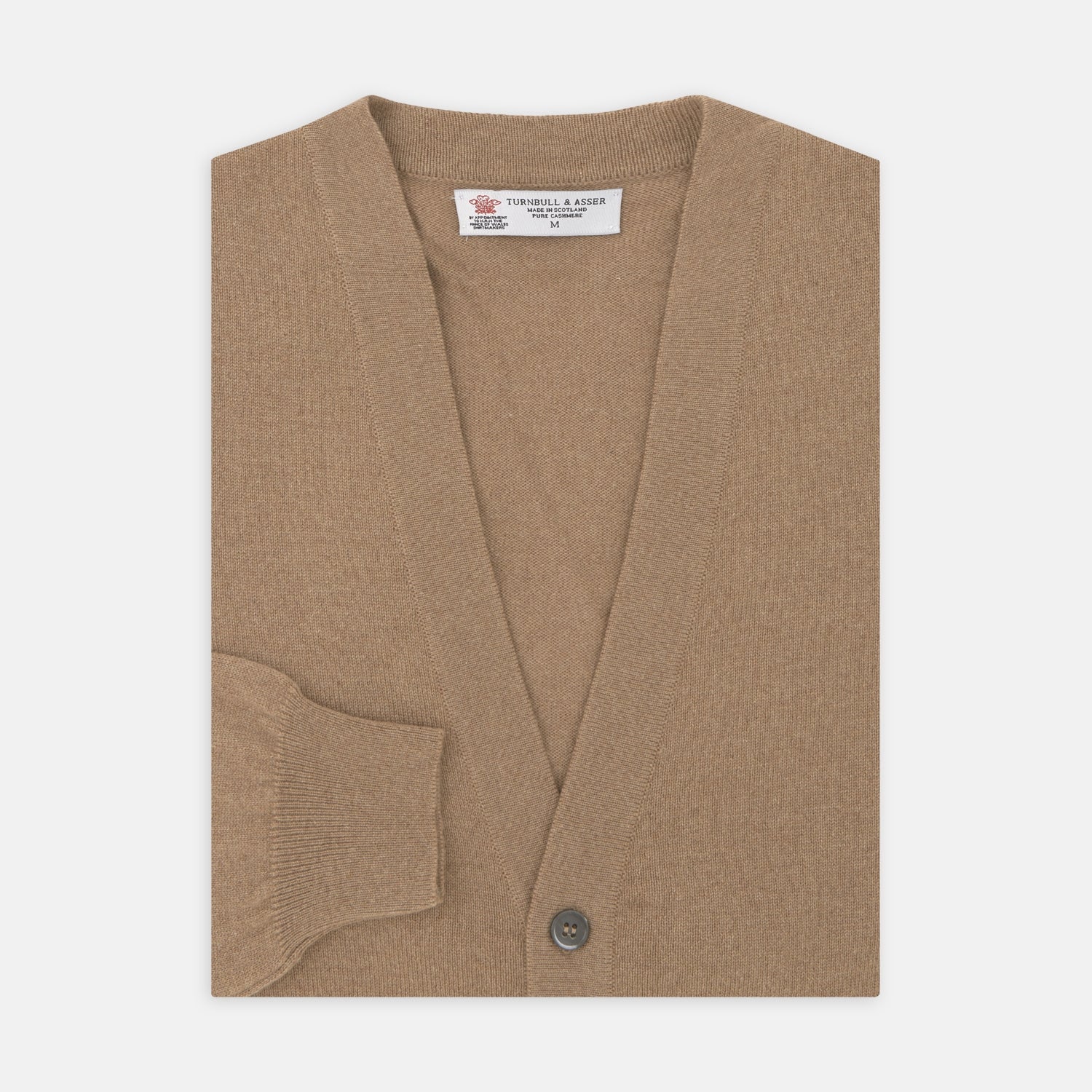 View 1 of product A Natural Cashmere Cardigan by Turnbull & Asser, light brown with a V-neckline, ribbed cuffs, and button closure, is neatly folded and displayed against a white background.